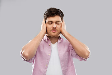 Image showing man closing ears by hands