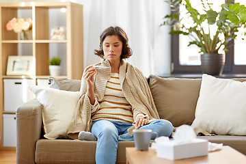 Image showing sick woman measuring temperature by thermometer