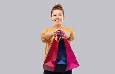 Image showing smiling red haired teenage girl with shopping bags