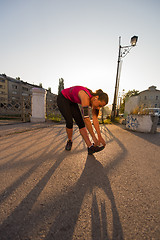 Image showing athlete woman warming up and stretching