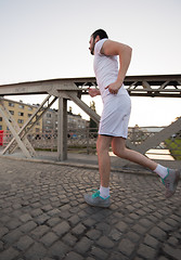 Image showing man jogging across the bridge at sunny morning