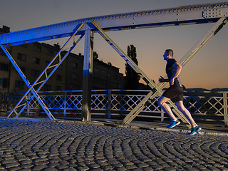 Image showing man jogging across the bridge in the city