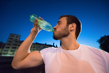 Image showing man drinking water after running session