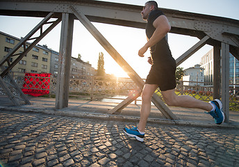 Image showing man jogging across the bridge at sunny morning