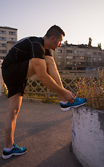 Image showing man tying running shoes laces