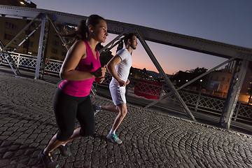 Image showing couple jogging across the bridge in the city