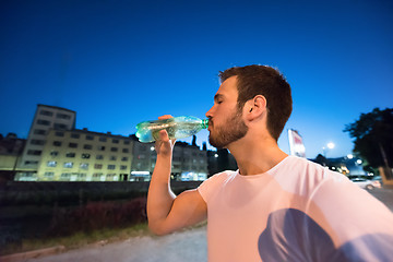 Image showing man drinking water after running session