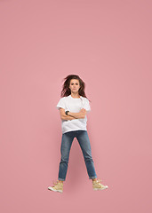 Image showing Freedom in moving. Pretty young woman jumping against pink background