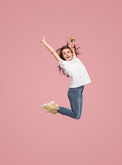 Image showing Freedom in moving. Pretty young woman jumping against pink background