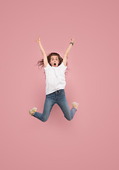 Image showing Freedom in moving. Pretty young woman jumping against pink background