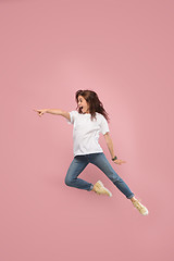 Image showing Freedom in moving. Pretty young woman jumping against pink background