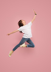 Image showing Full length of pretty young woman with mobile phone while jumping