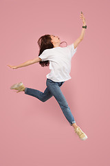 Image showing Full length of pretty young woman with mobile phone while jumping