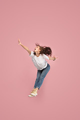 Image showing Freedom in moving. Pretty young woman jumping against pink background