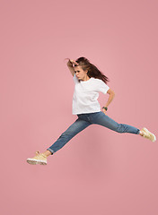 Image showing Freedom in moving. Pretty young woman jumping against pink background