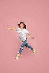 Image showing Freedom in moving. Pretty young woman jumping against pink background