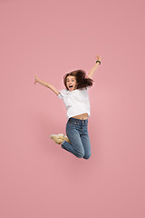 Image showing Freedom in moving. Pretty young woman jumping against pink background