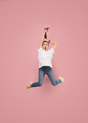 Image showing Freedom in moving. Pretty young woman jumping against pink background