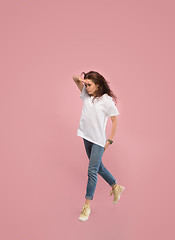 Image showing Freedom in moving. Pretty young woman jumping against pink background