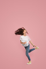 Image showing Freedom in moving. Pretty young woman jumping against pink background