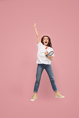 Image showing Beautiful young woman jumping with megaphone isolated over pink background