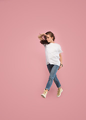 Image showing Freedom in moving. Pretty young woman jumping against pink background