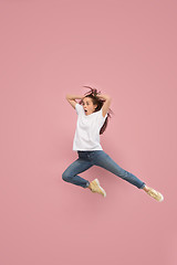 Image showing Freedom in moving. Pretty young woman jumping against pink background