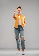 Image showing happy red haired teenage girl showing thumbs up