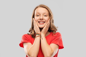 Image showing smiling teenage girl in red t-shirt over grey