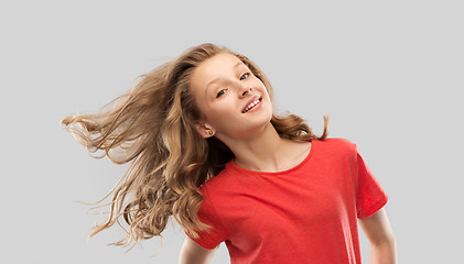 Image showing smiling teenage girl in red with long wavy hair