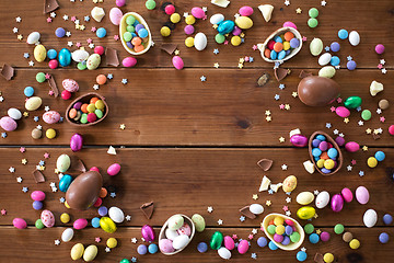 Image showing chocolate eggs and candy drops on wooden table