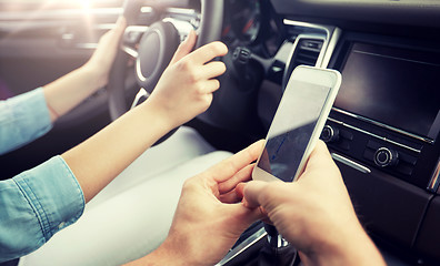 Image showing happy man and woman with smartphone driving in car