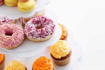 Image showing close up of glazed donuts and cupcakes on stand