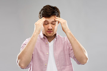 Image showing unhappy young man suffering from headache