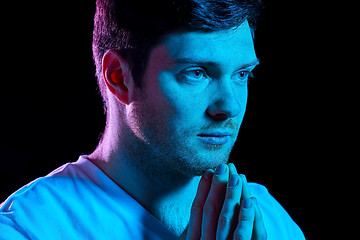 Image showing man praying god over ultra violet neon lights