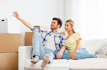 Image showing happy couple with cardboard boxes at new home