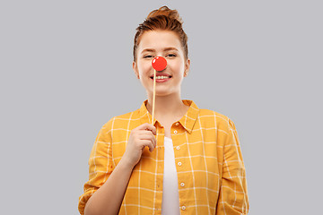 Image showing smiling red haired teenage girl with clown nose