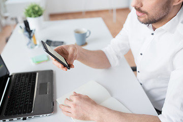 Image showing close up of businessman using smartphone at office