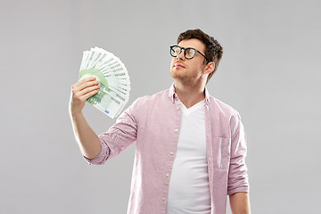 Image showing proud young man in glasses with fan of euro money