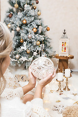 Image showing A woman holds a glittering christmas bauble for the tree