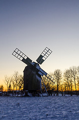 Image showing Wooden windmill by sunset in winter time