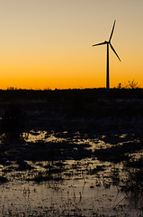 Image showing Windmill silhouette in a plain landscape with water reflections