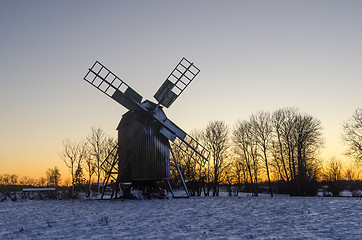 Image showing Traditional wooden windmill by sunset in winter season