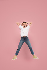 Image showing Freedom in moving. Pretty young woman jumping against pink background