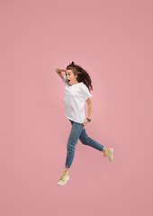 Image showing Freedom in moving. Pretty young woman jumping against pink background