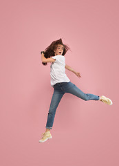 Image showing Freedom in moving. Pretty young woman jumping against pink background