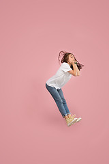 Image showing Freedom in moving. Pretty young woman jumping against pink background