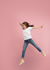 Image showing Freedom in moving. Pretty young woman jumping against pink background