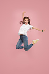 Image showing Freedom in moving. Pretty young woman jumping against pink background