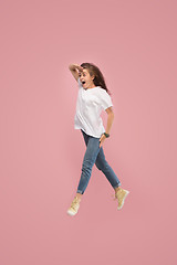 Image showing Freedom in moving. Pretty young woman jumping against pink background